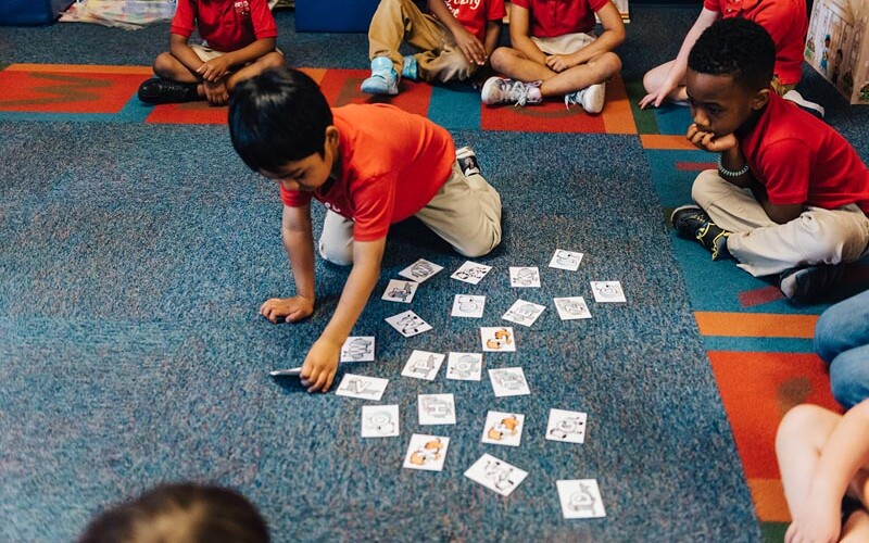 Pre-K children sorting cards on the classroom rug at Beary Cherry Tree in Metairie
