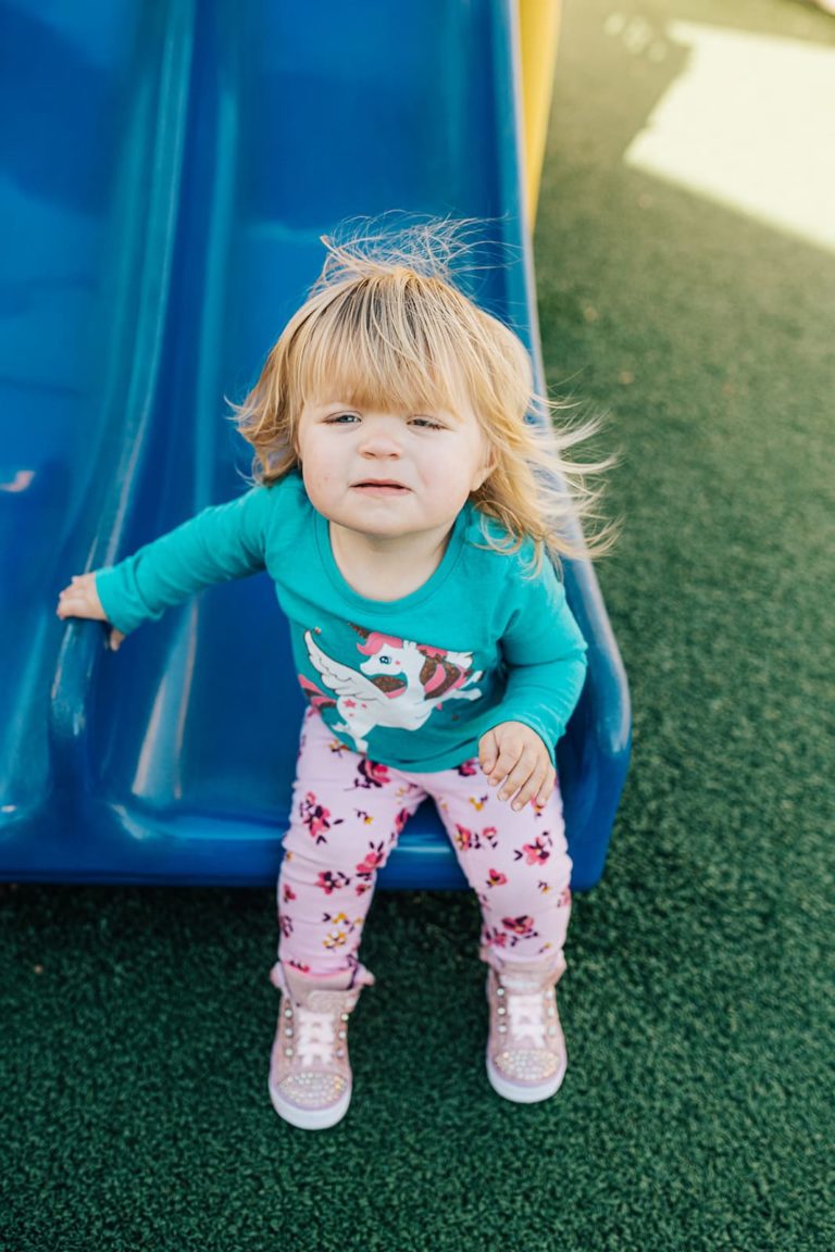Toddler at the bottom of the slide on the playground at Beary Cherry Tree
